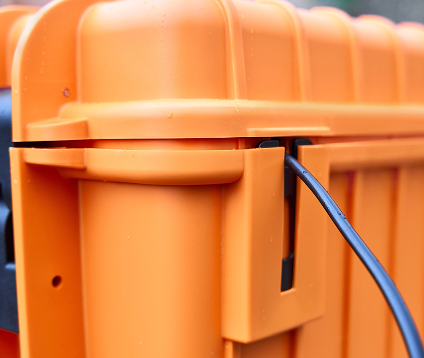Detailed view of the orange battery case with cable guide.
